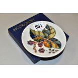 A BOXED MOORCROFT POTTERY CIRCULAR PIN DISH DECORATED WITH A BLACKBERRIES AND BRAMBLE DESIGN, on a