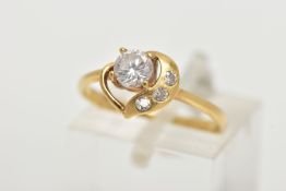 A YELLOW METAL CUBIC ZIRCONIA DRESS RING, of an open heart design set with four colourless cubic