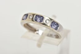 A 9CT WHITE GOLD HALF ETERNITY RING, designed with a row of three rectangular cut light purple cubic
