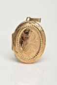 A 9CT GOLD OVAL LOCKET PENDANT, foliage engraved design to the front and a plain polished reverse,