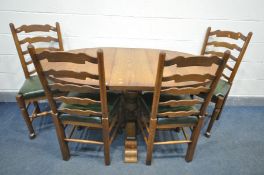 A REPRODUCTION SOLID OAK OVAL EXTENDING DINING TABLE, with a single additional leaf, on an acorn