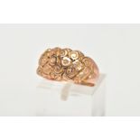 A 9CT GOLD DOME RING, a wide band detailing a floral and scrolling pattern, approximate width