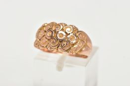 A 9CT GOLD DOME RING, a wide band detailing a floral and scrolling pattern, approximate width