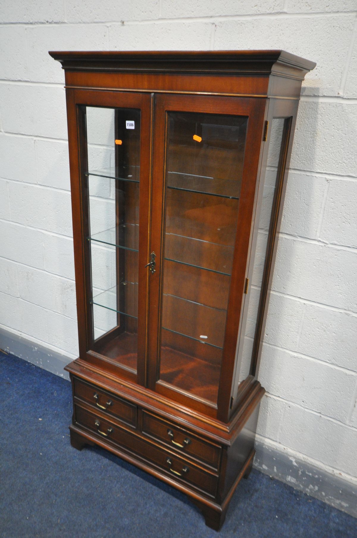 A BRADLEY MAHOGANY GLAZED TWO DOOR BOOKCASE, with three glass shelves, over three drawers, width
