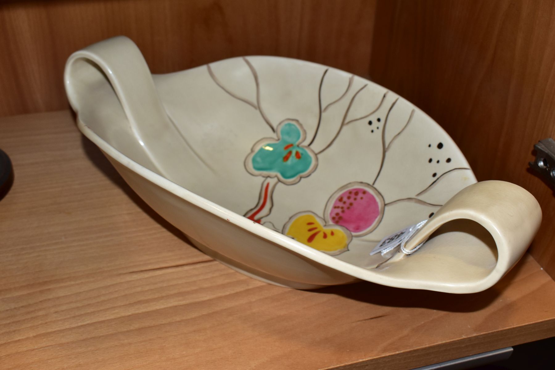 A CLARICE CLIFF WILKINSON LTD POTTERY TWIN HANDLED OVAL BOWL PAINTED WITH A FRUITING POMEGRANATE