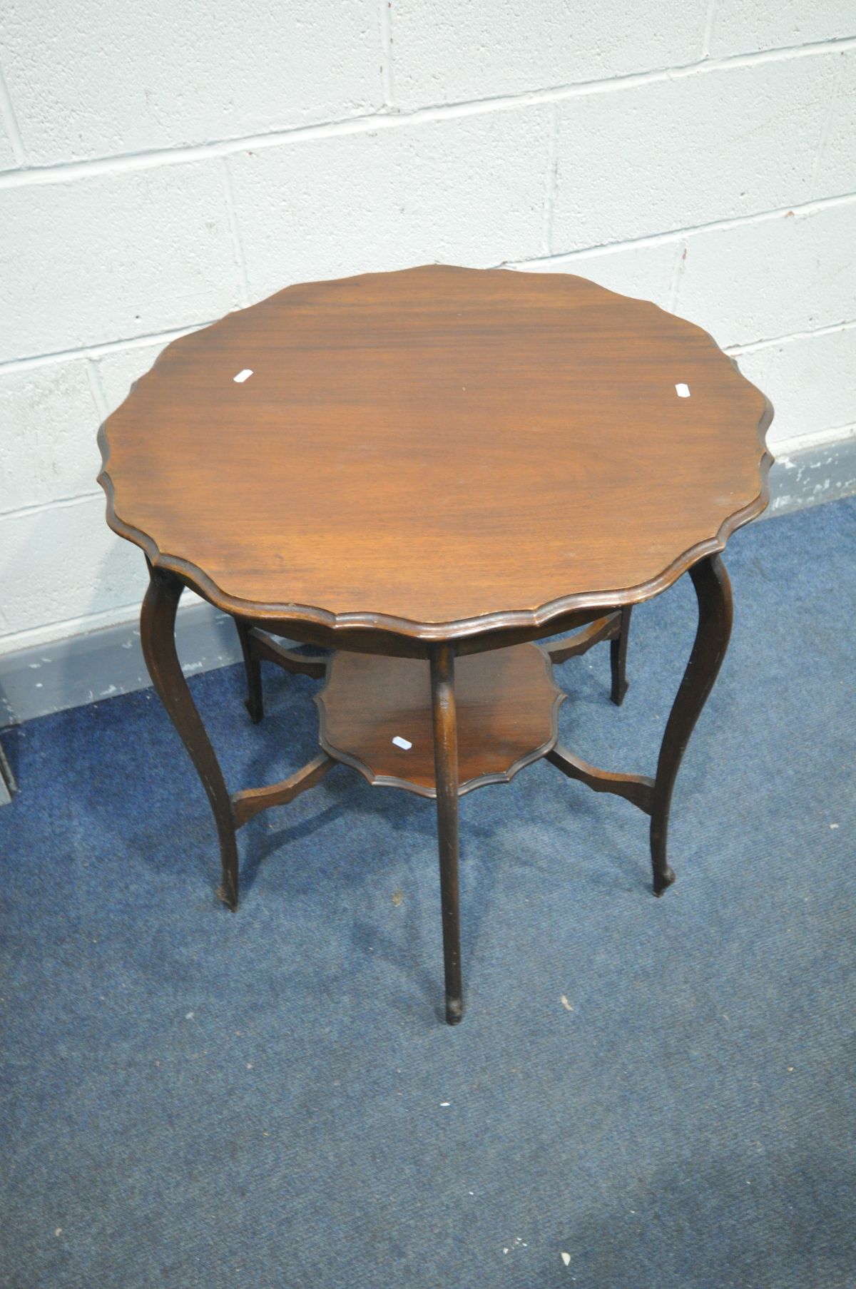 AN EARLY 20TH CENTURY MAHOGANY CENTRE TABLE, with wavy edges, united by a similar undershelf,