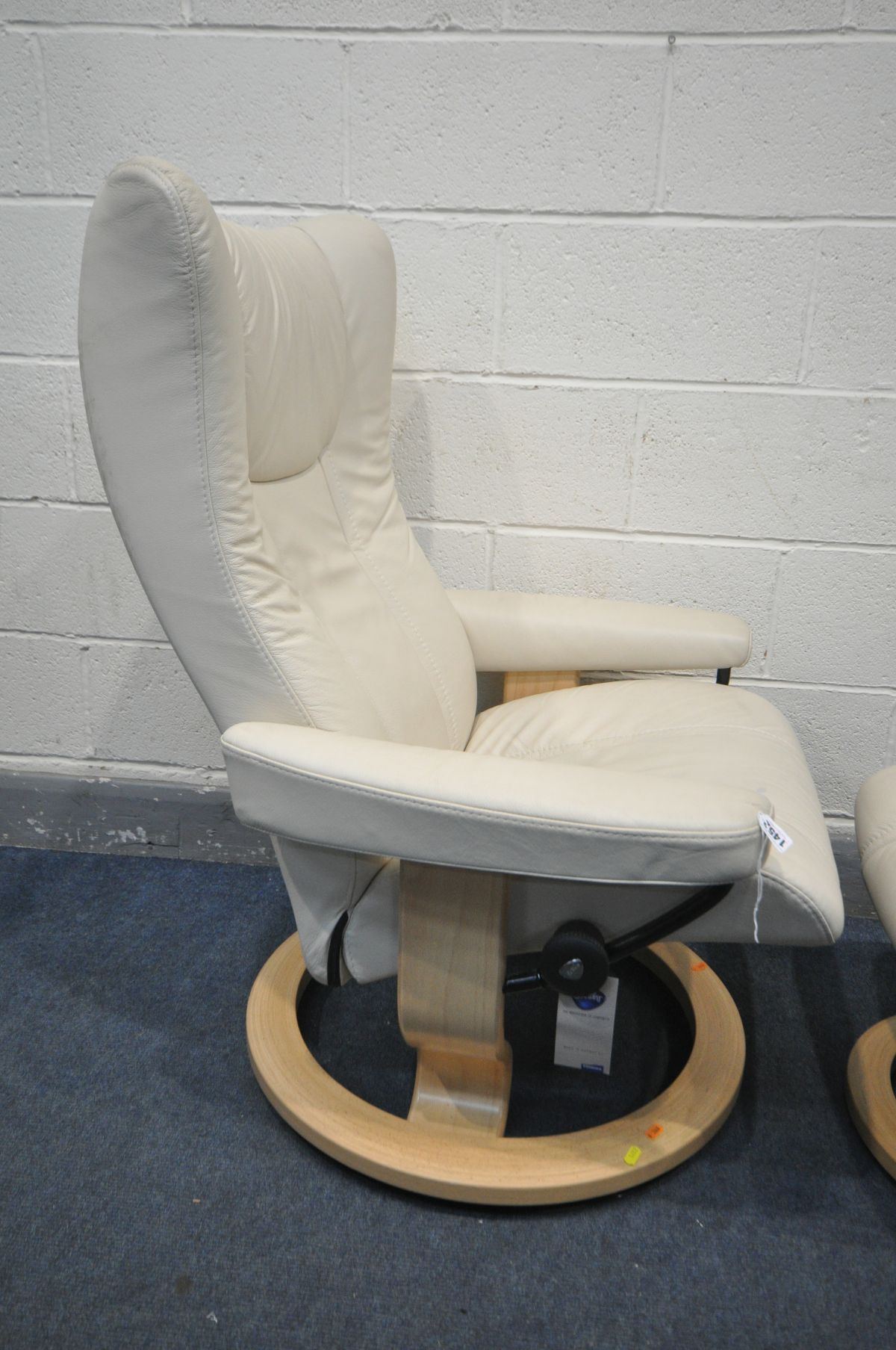 AN EKORNES STRESSLESS CREAM LEATHER RECLINING SWIVEL ARMCHAIR, and a matching pouffe (in nearly - Image 2 of 2