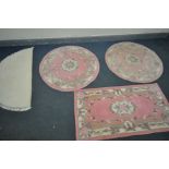 TWO CHINESE PINK CIRCULAR RUGS, diameter 122cm, a similar rectangular rug, and a cream half-moon rug