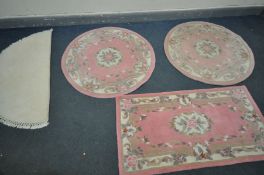 TWO CHINESE PINK CIRCULAR RUGS, diameter 122cm, a similar rectangular rug, and a cream half-moon rug