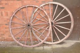 A PAIR OF VINTAGE WOODEN CARTWHEELS with iron banded rim and hub centre, diameters 168cm (some paint