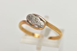 AN AF YELLOW METAL DIAMOND RING, of a cross over design with a central illusion set single cut