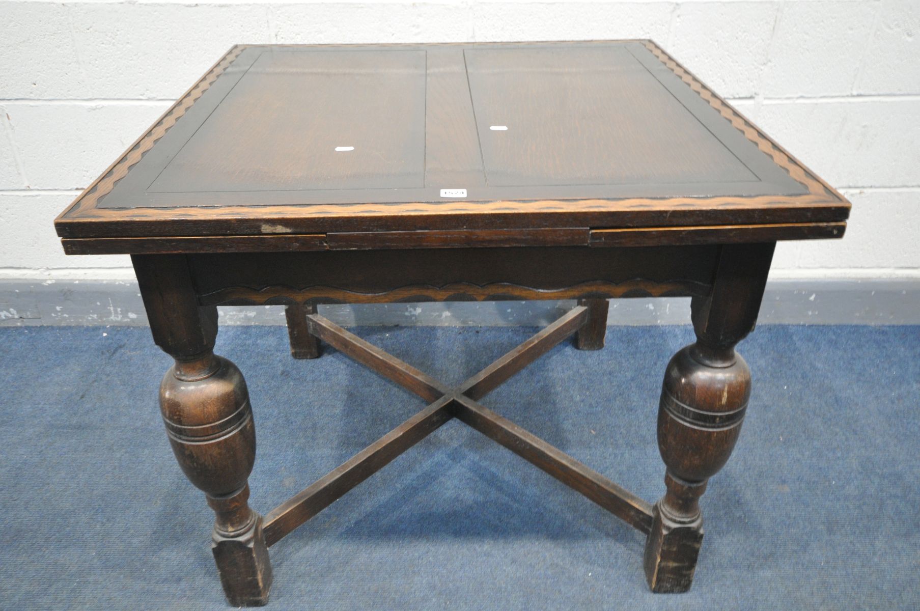 AN OAK DRAW LEAF DINING TABLE, with a wavy carved border, on bulbous legs, united by a cross - Image 4 of 4