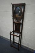 A SLIM EARLY TO MID 20TH CENTURY OAK HALL STAND, with a swinging oval mirror, width 42cm x depth