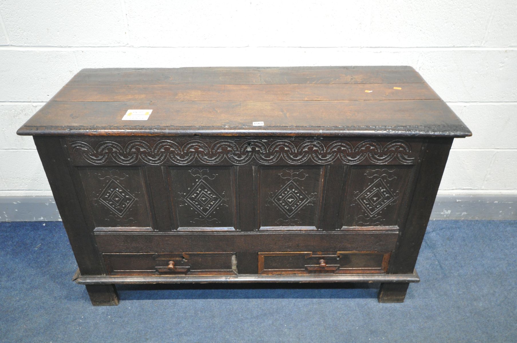 AN 18TH CENTURY OAK MULE CHEST, the hinged plank top enclosing a candle box, and panelled front