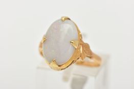 A CHINESE YELLOW METAL OPAL RING, centring on a large white opal cabochon showing flashes of red,