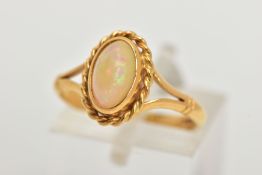 AN 18CT GOLD OPAL RING, designed with an oval cut white opal cabochon, showing flashes of red,