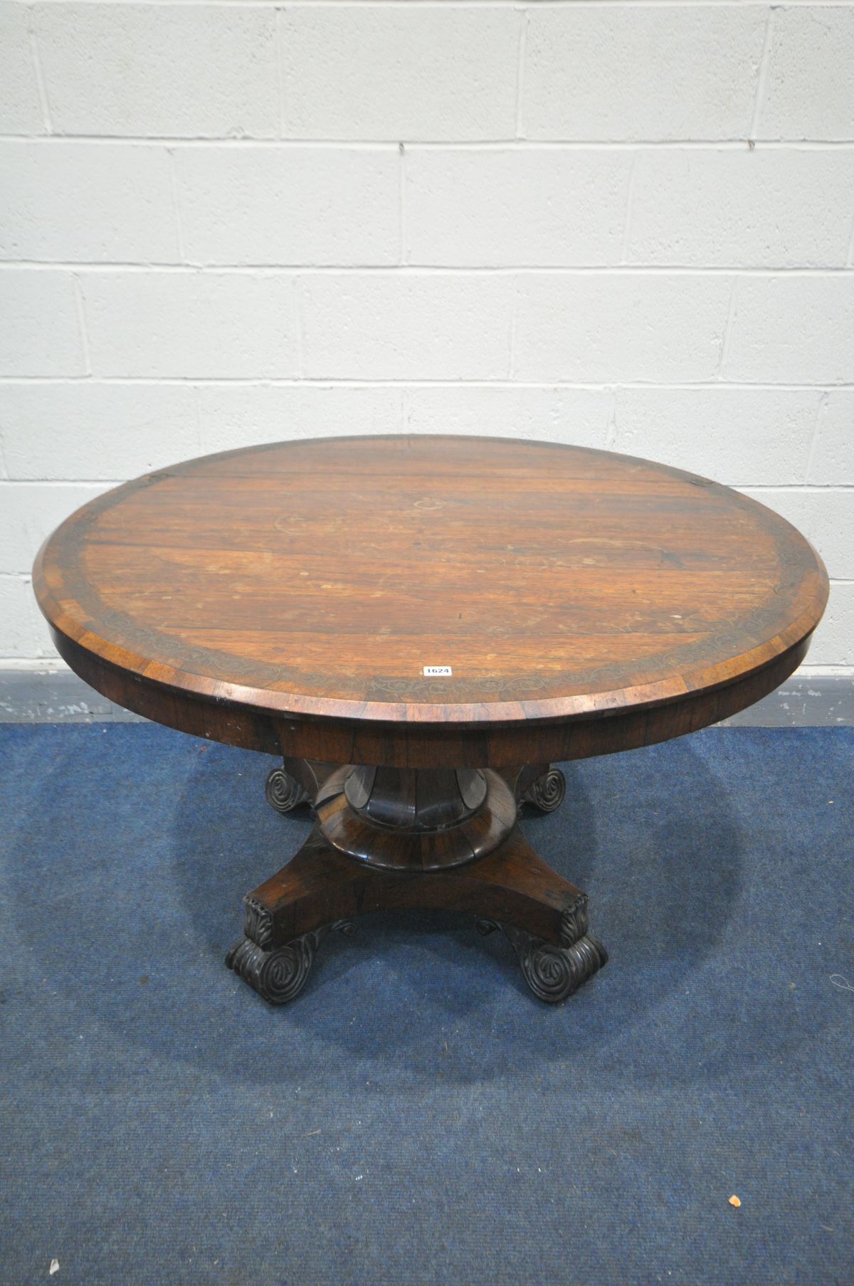 A GEORGE IV ROSEWOOD BREAKFAST TABLE, the circular tilt-top with a foliate brass inlaid border, on a