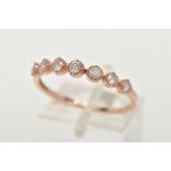 A 9CT ROSE GOLD DIAMOND HALF ETERNITY RING, designed with a row seven round brilliant cut