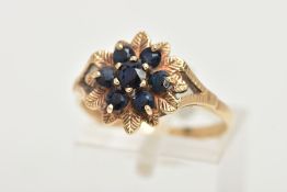 A 9CT GOLD SAPPHIRE CLUSTER RING, of a flower form, set with seven circular cut deep blue sapphires,