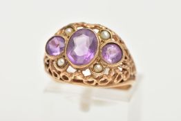 A YELLOW METAL AMETHYST AND SEED PEARL DRESS RING, centring on an oval cut amethyst milgrain