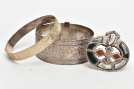 TWO BANGLES AND A SCOTTISH BROOCH, the first a silver hinged bangle decorated with a diamond cut