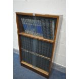 A GLAZED BOOKCASE, containing the Britannica Dictionary, the new book of Knowledge and Encyclopaedia