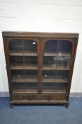 AN EARLY TO MID 20TH CENTURY OAK GLAZED TWO DOOR BOOKCASE, with three adjustable shelves, later