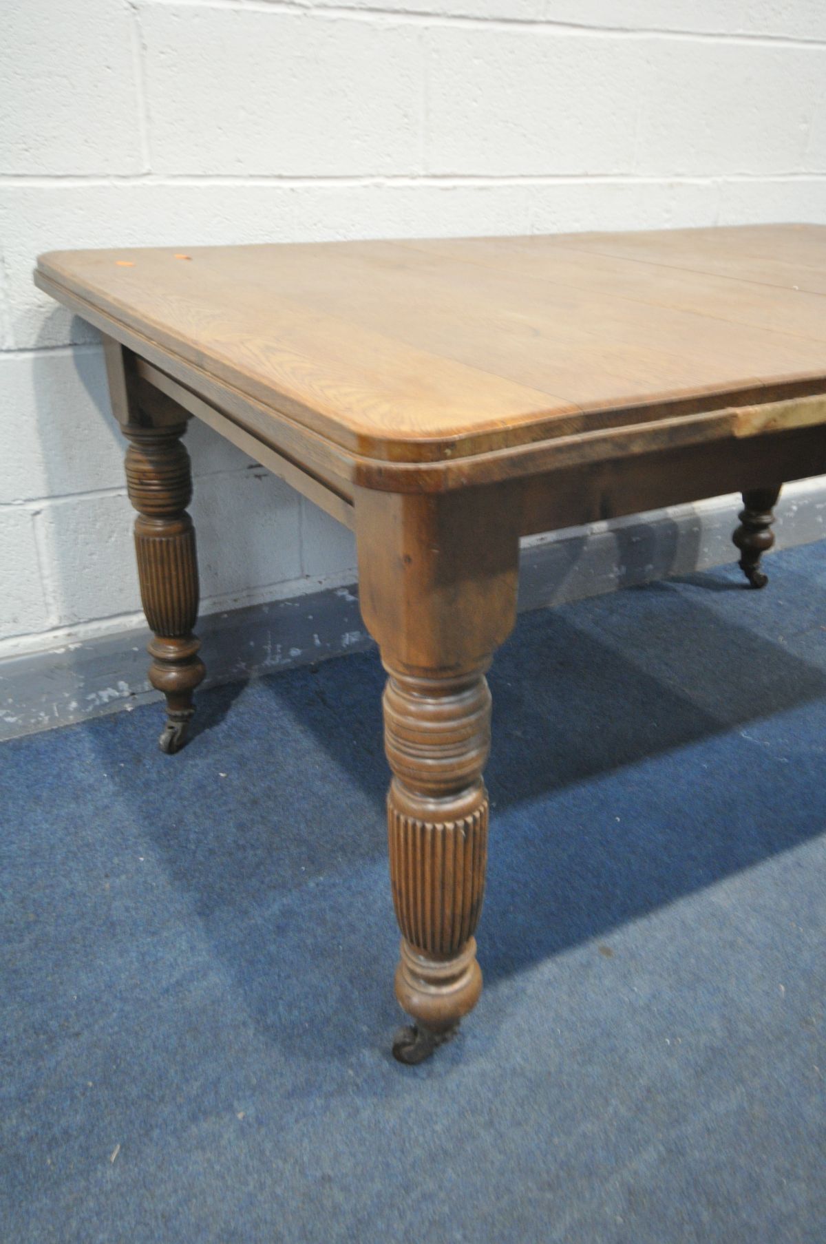 AN EDWARDIAN OAK DINING TABLE, on turned and fluted legs, on ceramic casters, width 153cm x depth - Image 2 of 2