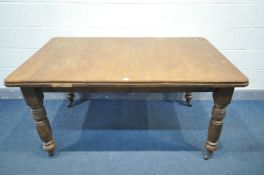 AN EDWARDIAN OAK DINING TABLE, on turned and fluted legs, on ceramic casters, width 153cm x depth