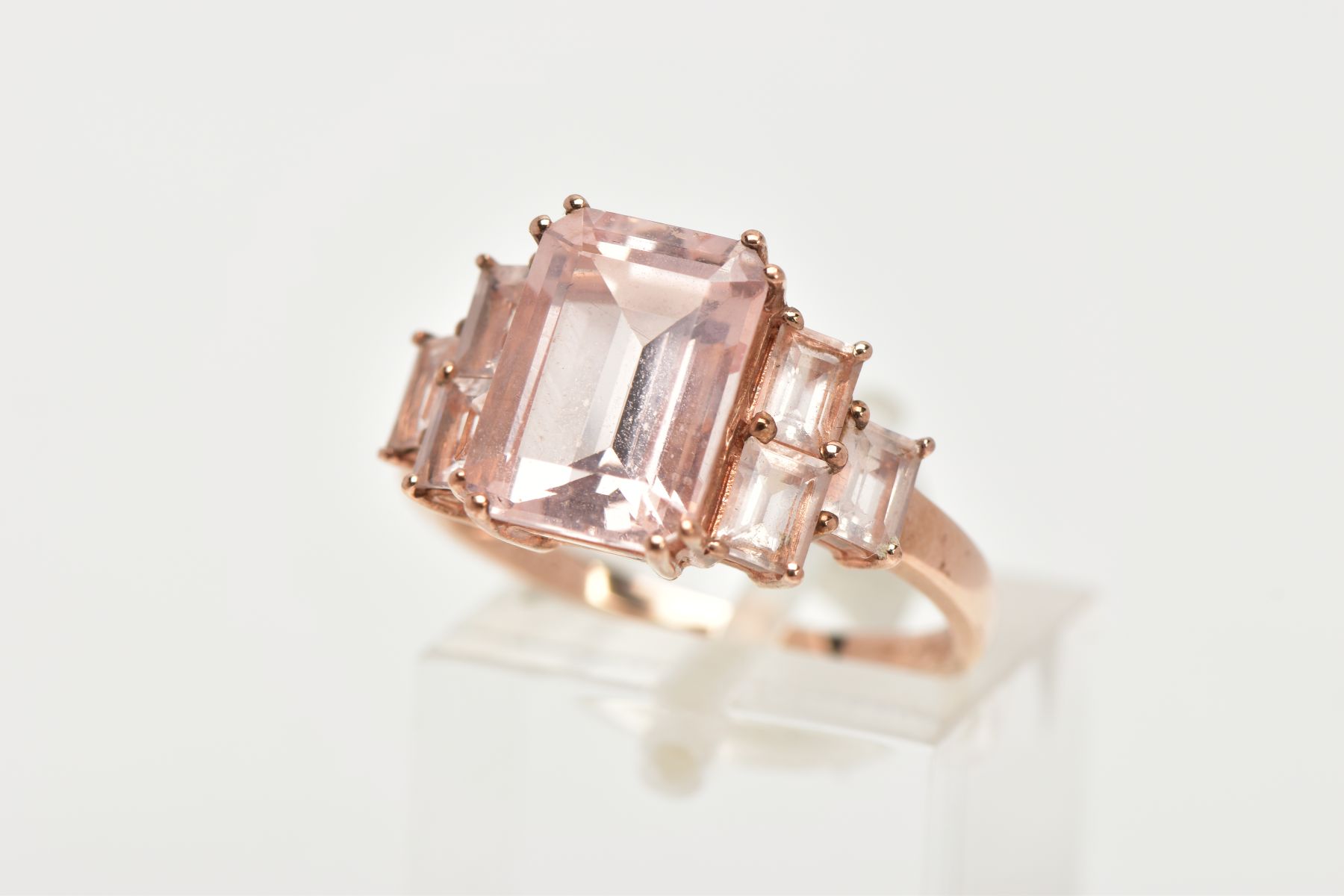 A 9CT ROSE GOLD MORGANITE DRESS RING, of a tiered design, set with a central rectangular cut