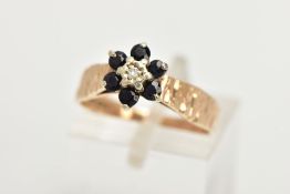 A 9CT GOLD SAPPHIRE AND DIAMOND CLUSTER RING, of a flower design set with a central single cut