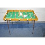 A FRENCH TABLE FOOTBALL TABLE, on folding metal legs, along with playing balls, length 110cm x depth