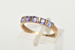 A 9CT GOLD TANZANITE HALF HOOP RING, designed with a row of five bar set, square cut tanzanite's,