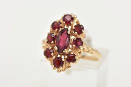 A 14CT GOLD GARNET RING, of an oval form, set with a central marquise cut garnet within a surround