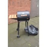 A CHAR-GRILLER PROFESSIONAL METAL BARBECUE in barrel form with side shelf, undershelf and cover,