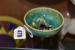 A MOORCROFT POTTERY SMALL FOOTED DISH DECORATED WITH AN ORCHID PATTERN ON A MOTTLED GREEN GROUND,