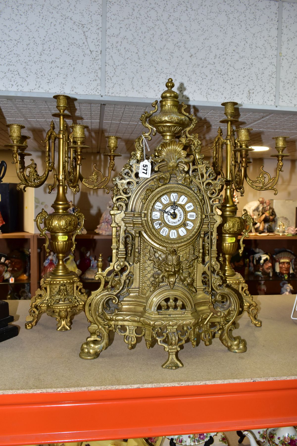 A REPRODUCTION BRASS CLOCK GARNITURE, the clock with ornate cast brass case with twin handled urn