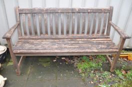 A HARDWOOD GARDEN BENCH with slatted seat and back with a brass plaque from the Moor Hall Luncheon