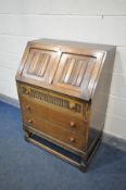 AN OAK LINENFOLD BUREAU, with three drawers, width 77cm x depth 47cm x height 108cm