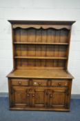 A REPRODUCTION OAK DRESSER, the top with a two tier plate rack, with three drawers, width 137cm x