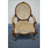 A VICTORIAN WALNUT BUTTONED SPOONBACK ARMCHAIR, with foliate carved cresting, open armrests,
