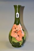 A MOORCROFT CORAL HIBISCUS PATTERN BOTTLE VASE, on green ground, stamped to underside of base,