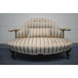 A LATE VICTORIAN CANAPE SOFA, with a shaped back and open arm rests, on scrolled front legs, a