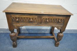 A MID CENTURY REPRODUCTION SOLID OAK SIDE TABLE, with two frieze drawers, chip-carved apron, on