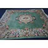 A LARGE CHINESE GREEN GROUND WOOLLEN RUG, with foliate design to centre and border, length 370cm x