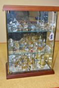 A GLASS DISPLAY CABINET CONTAINING CRYSTAL STYLE ORNAMENTS, to include animals, musical instruments,