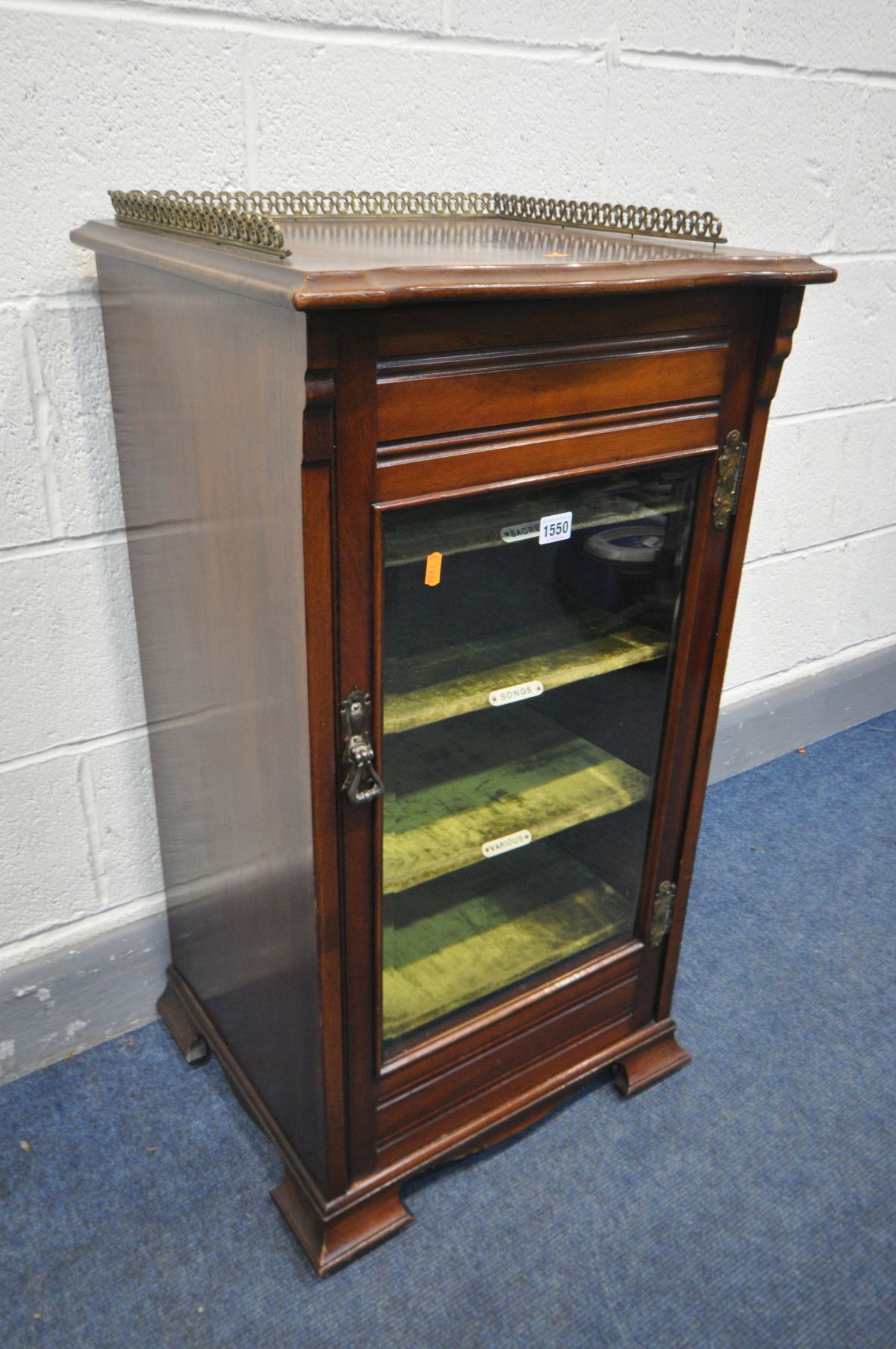 AN EDWARDIAN MAHOGANY MUSIC CABINET with a brass gallery, on casters, width 49cm x depth 43cm x