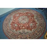 A LARGE CIRCULAR RED GROUND RUG, with a foliate design, 240cm diameter, along with two Chinese rugs,