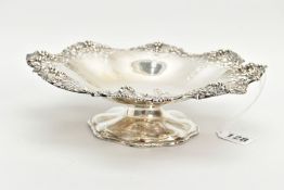 A SILVER PIERCED BONBON DISH, wavy flower shape with a pierced grape vine detailed rim, raised on