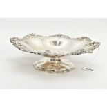 A SILVER PIERCED BONBON DISH, wavy flower shape with a pierced grape vine detailed rim, raised on